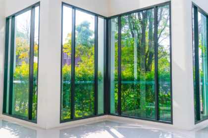 Glass window overlooking green garden .